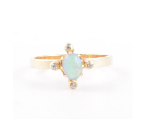 An  opal and diamond dress ring, the oval cabochon cut stone  5.5mm x 3.5mm having a small old cut diamond collet set to each