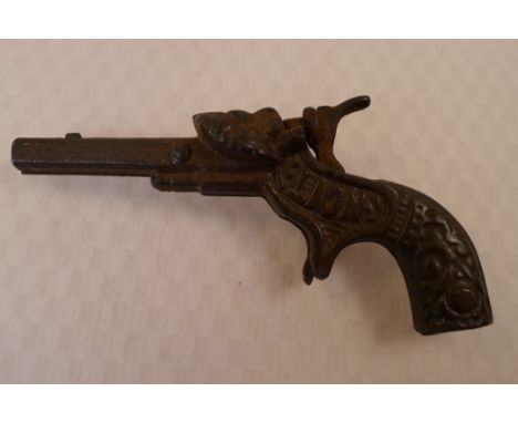 A vintage Lion figural cast iron toy cap gun, approx 13.5cm , 5.25 inch long, has the word Lion cast into left side and unusu