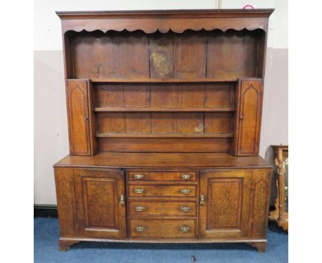 A GEORGIAN OAK CROSSBANDED WELSH DRESSER, the enclosed upper section with two crossbanded cupboards, above a lower section wi