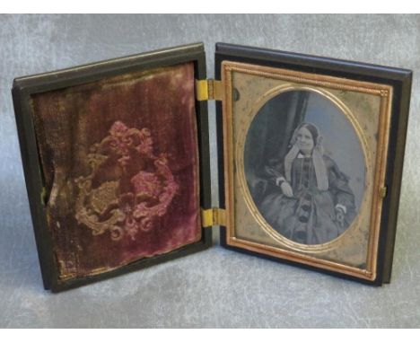 A 19TH CENTURY AMERICAN AMBROTYPE OF A SEATED LADY, in decorative case, portrait size 9 x 6.5 cm, case size 10 x 12 cm