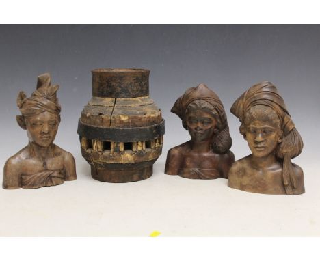 THREE INDONESIAN TRIBAL ART CARVED TEAL WOOD BUSTS, and a large heavy Indian cartwheel hub