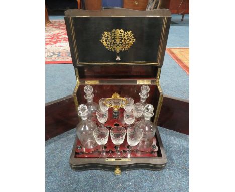 A 19TH CENTURY EBONISED AND BRASS INLAID DOMED DRINKS CABINET, the hinged lid opening to reveal and lift-out stand for four d