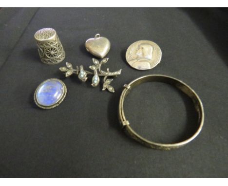 A SMALL TRAY CONTAINING A FILIGREE THIMBLE, silver heart locket, a silver child's bangle, butterfly wing brooch, silver blueb