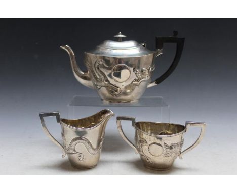 A CHINESE EXPORT SILVER THREE PIECE TEA SERVICE, boldly embossed with a three toed dragon, character marks to base, approx we