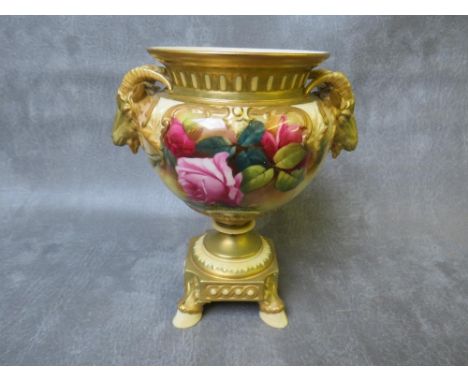 A ROYAL WORCESTER BLUSH IVORY PEDESTAL VASE, decorated with roses , having rams head masks to each side, raised on four hoof 