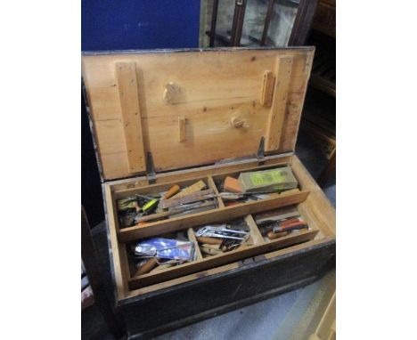 A pine tool chest containing a large selection of tools to include wood working planes, drill pieces, saws and other items 