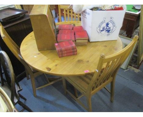 A modern pine circular topped dining table, 30" h x 47 1/2" w and a set of four Ercol chairs 