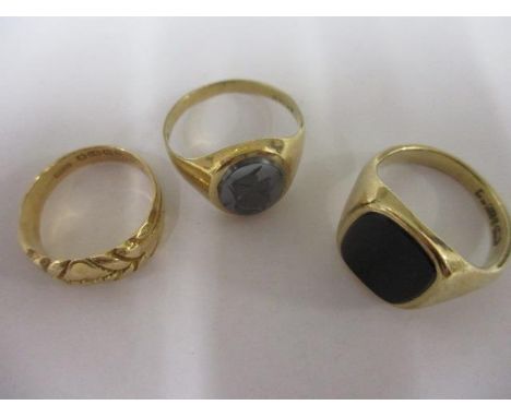 An 18ct gold gentleman's dress ring, together with two 9ct gold gents signet rings, one inset with a black panel 