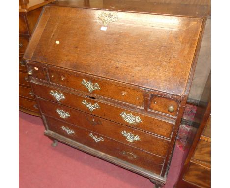 A 19th century provincial oak slopefront writing bureau, having three short over three long graduated drawers to squat cabrio