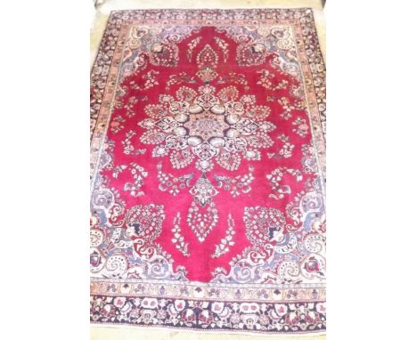 A Persian Tabriz carpet with large central medallion on a red ground 312 x 220cm