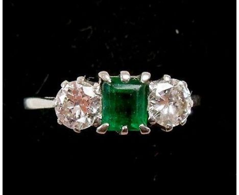 A platinum ring set emerald flanked by two diamonds (each diamond just under 0.5 carat)