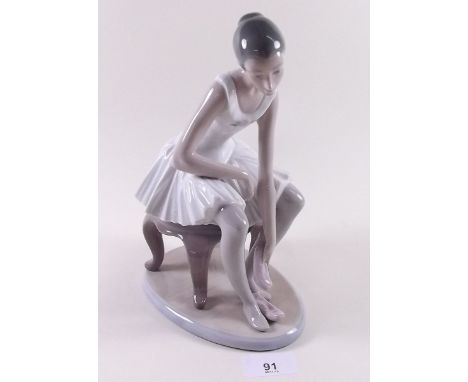 A Lladro Nao figure of seated ballerina 