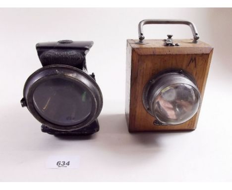 A Silver King Lucas japanned bicycle headlamp with green side lenses and a wooden EverReady hand lamp