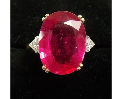 An 18 carat gold ring set oval cut ruby on diamond set shoulders 