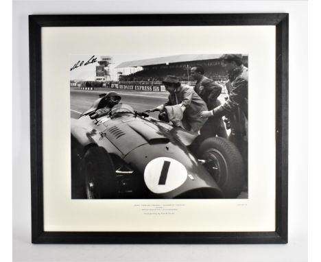 A signed reprinted photograph of Juan Manuel Fangio, in a Scuderia Ferrari at the British Grand Prix in silverstone 1956, pho