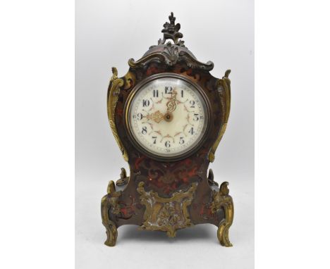 A late 19th/early 20th century French Boulle mantle clock, the red tortoiseshell case having a metal flowers shaped finial wi