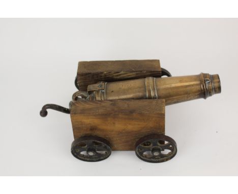 A 19th century signal cannon, with a bronze barrel and metal handle, with later wooden sides and base, on cast iron wheels, b