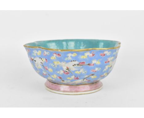 A Chinese Qing dynasty porcelain footed lotus bowl, the exterior with blue enamel ground decorated with red-crowned cranes in