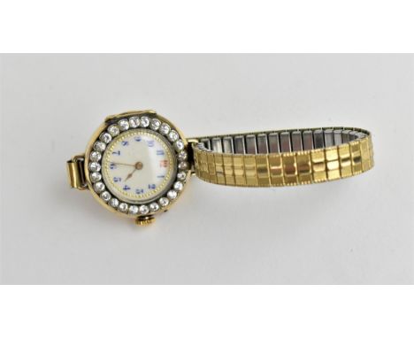 A ladies early 20th century manual wind 18ct gold cased wristwatch having a white enamel dial with Arabic numerals and gold c