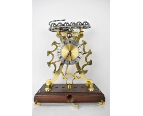 A mid 20th century Comitti Of London spherical rolling ball mantle clock, the dial having a brass centre and silvered chapter