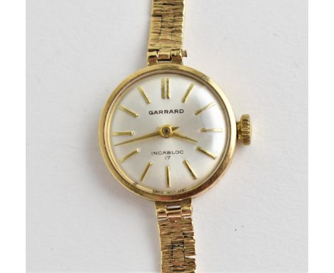 A vintage ladies 9ct gold cased manual wind Garrard wristwatch having a silvered dial with baton hour markers, dial signed in