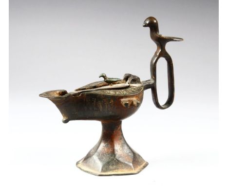 A BRONZE SELJUK LAMP, with bird shaped handle and finial, 15cm high.