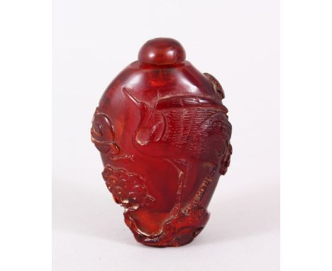 A GOOD QIANLONG CHINESE CARVED AMBER SNUFF BOTTLE, decorated with scenes of cranes amongst pine trees, bearing a qianlong sea