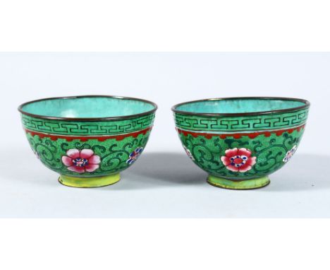 A PAIR OF 19TH / 20TH CENTURY CHINESE ENAMEL CUPS, decorated upon a green ground with formal foliage, 4.5cm high x 8cm diamet