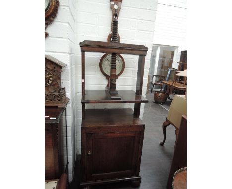 A 19th century oak book case having twist framed top on adjustable shelf over panel cupboard and bun feet