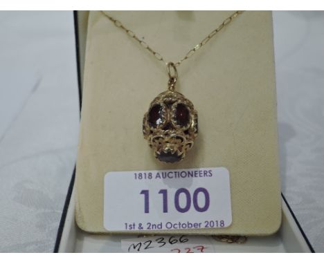 A 9ct gold lantern style pendant having garnet decoration on a 9ct gold chain