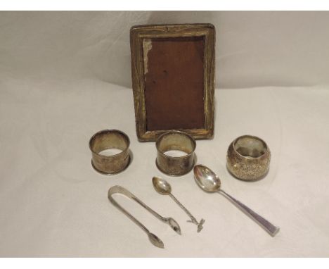 A small selection of HM silver including an early 20th century photograph frame of rectangular form with wooden easel back, a