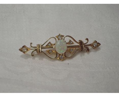 A yellow metal bar brooch having a central oval cabouchon opal within a diamond set surround, no marks but tested as 14ct gol