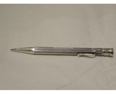 A silver propelling pencil of octagonal form having engine turned decoration and monogrammed S Sutton, hallmark London 1938, 