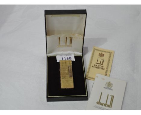 A Dunhill rollagas gold plated lighter having chequered cut decoration in original box with paperwork