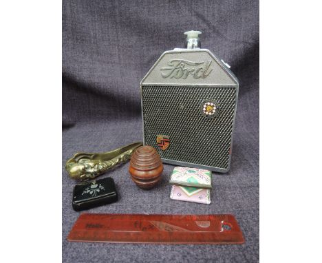 A 1960's Japanese musical plastic decoration modelled as a Ford car radiator, a treen nutmeg grinder, a Bilston enamel style 