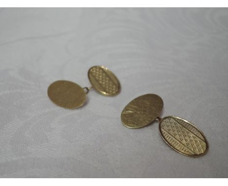 A pair of 9ct gold cufflinks of oval form having engine turned decoration and chain connectors,  approx 4g