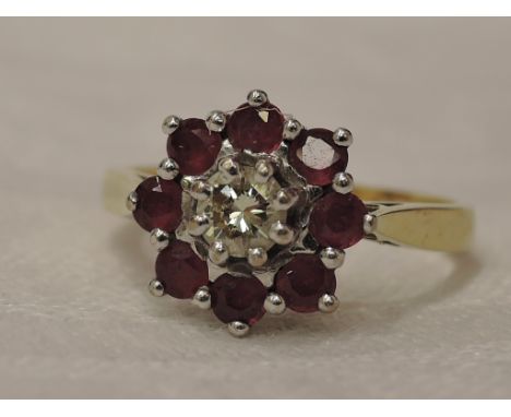 A lady's dress ring having a diamond and ruby cluster in a stepped claw mount on an 18ct gold loop,  size L