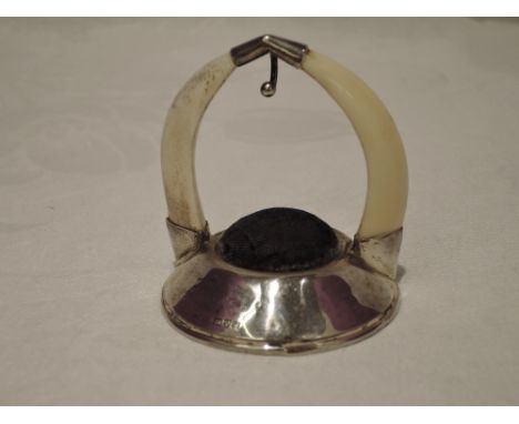 A silver and boars tusk pocket watch stand of plain form with blue velvet pin cushion below. Chester 1923, makers mark worn