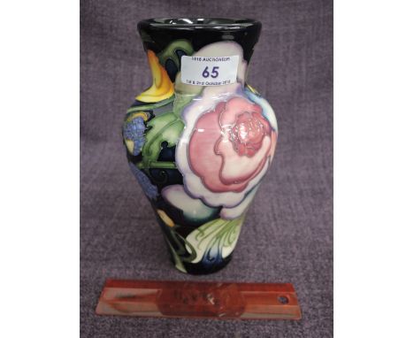 A modern Moorcroft vase having stylised floral decoration on blue ground, with original ticket, seconds