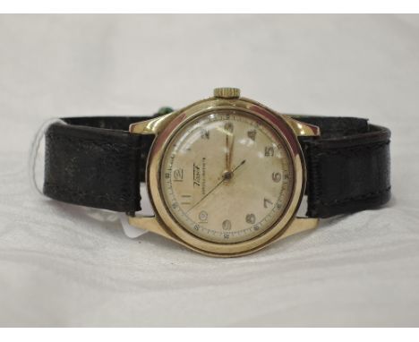 A gents 9ct gold wrist watch by Tissot having an Arabic numeral dial with perimeter seconds dial on a black leather strap wit