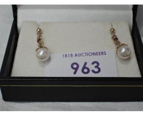 A pair of 9ct gold stud earrings having ruby set drops to cultured pearl terminals