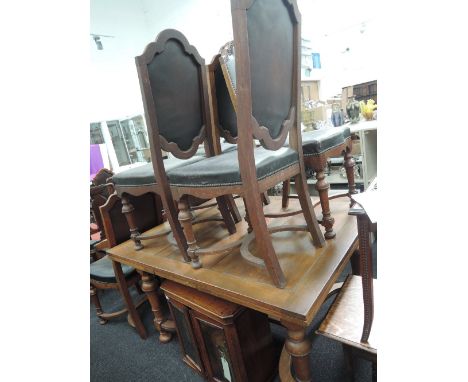 A mid 20th century oak dining suite comprising draw leaf table on turned legs and X frame and a set of eight (6+2) dining cha