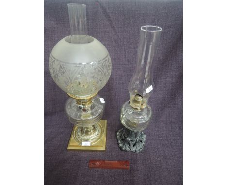 An early 20th century oil lamp having clear ribbed glass reservoir, on brass base and with later etched shade, and a similar 