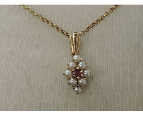 A seed pearl and ruby pendant in a 9ct gold lozenge shaped mount on a 9ct gold chain