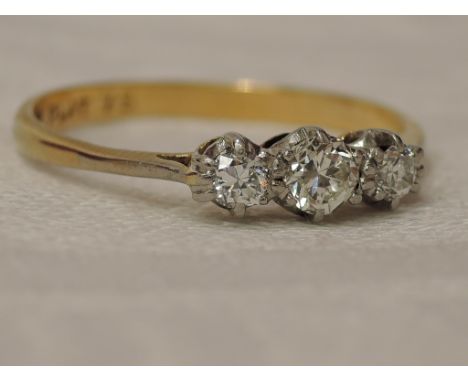 A lady's dress ring having a trilogy of diamonds, total approx 0.25ct in a claw set mount on a yellow metal loop stamped 18ct