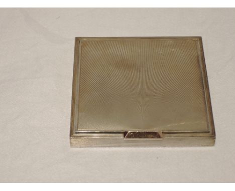 A silver powder compact of square form having engine turned star burst decoration, rose gold slide catch stamped 14K and remo