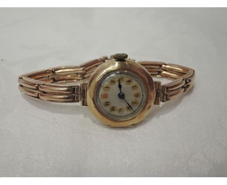 A lady's vintage 9ct gold wrist watch having Arabic numeral dial to circular face on a rose metal stretch strap stamped 9ct w
