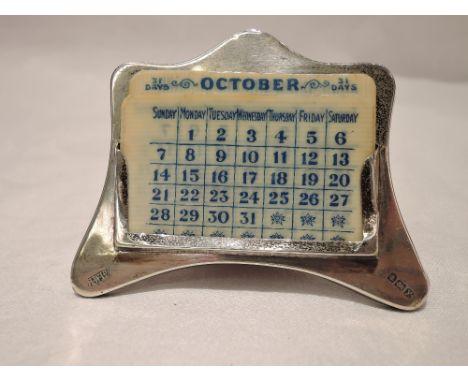 A small silver framed perpetual calendar having plain arched frame and wooden easel back, Birmingham 1923, Henry Williamson L
