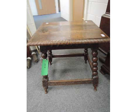 An early 20th century oak occasional table having rectangular top with carved border on splay bobbin frame