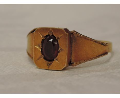 A Victorian 18ct gold signet ring having a ruby in starburst setting to tapered shoulders with rope wire decoration, Chester 